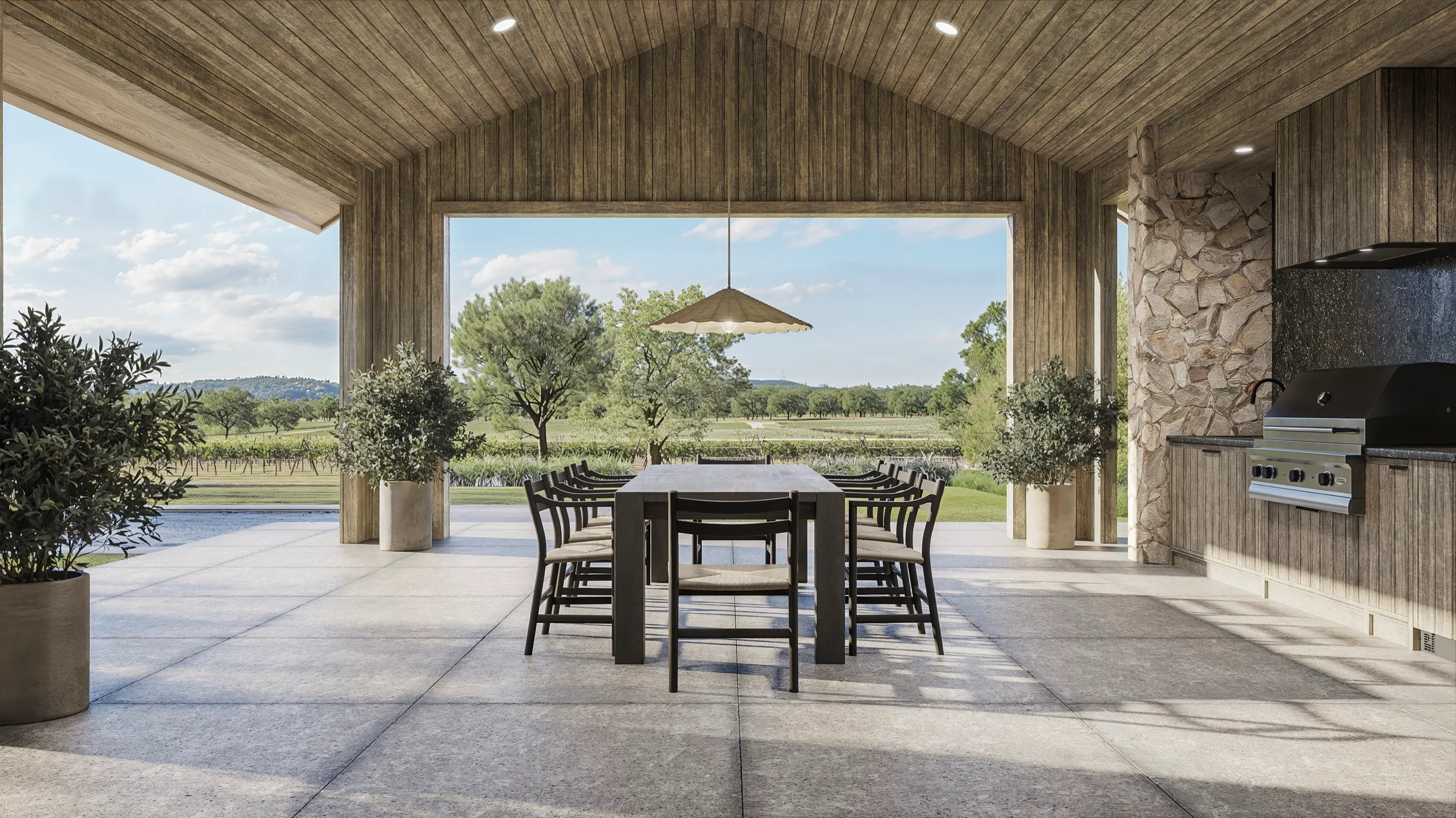 3D rendering of the covered outdoor kitchen at a Napa Valley estate in St. Helena, a board-ceilinged pavilion with a stone-clad grill, a long dining table, and an open gable framing the vineyards and hills beyond.