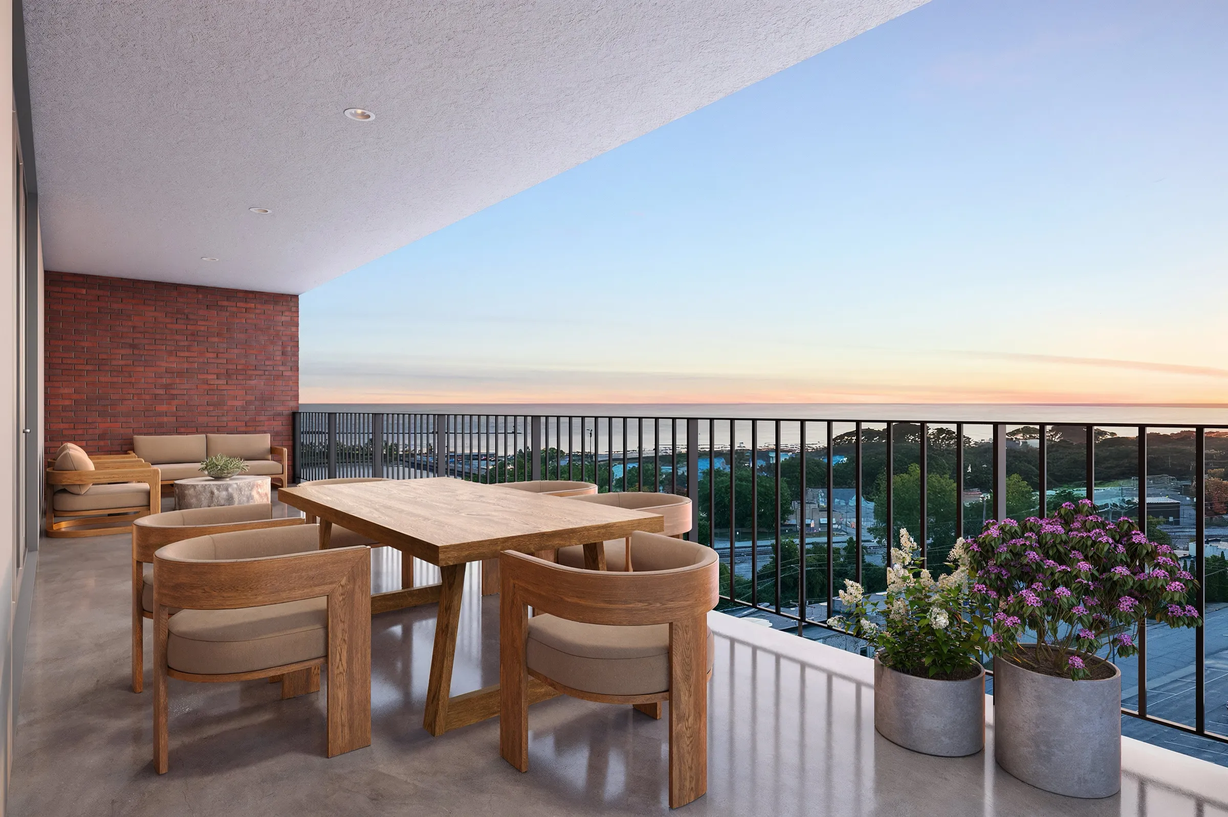 Dusk 3D rendering of the covered terrace of Residence 925 at SoLa in Michigan City, Indiana, with a wood dining table and chairs, a brick accent wall, black wrought-iron railings, and a view over the town toward Lake Michigan.