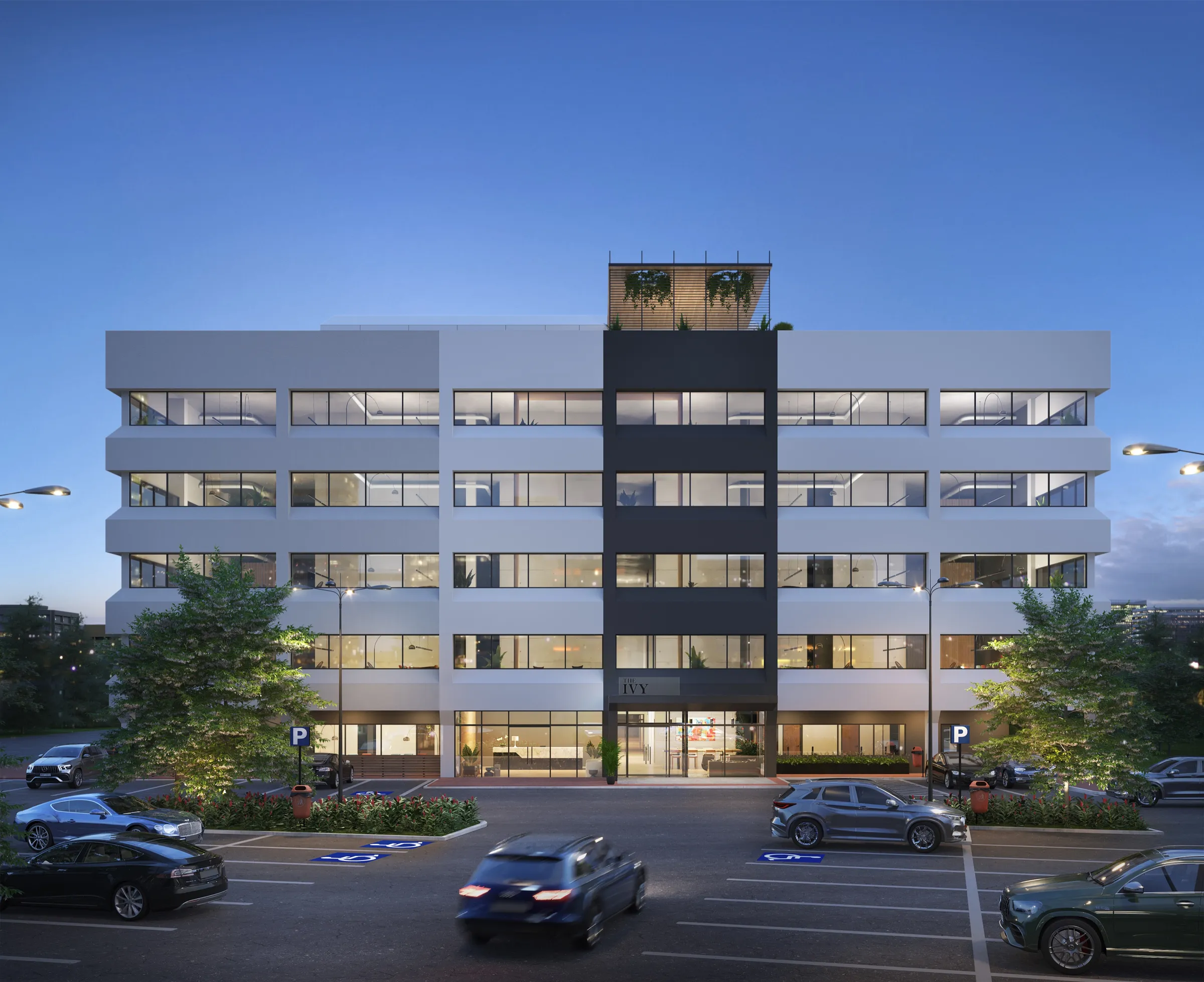 Dusk 3D rendering of The Ivy, a five-story boutique office building at 2 Vantage Way in Metrocenter, Nashville, its pale floor bands wrapping glass floors around a dark central entry bay lettered IVY, with a rooftop garden pavilion above and a parking lot in front.