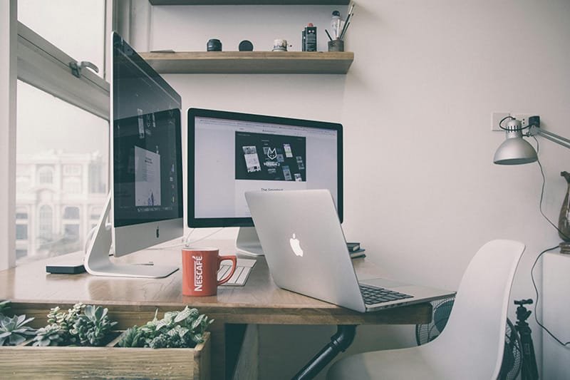 desk with many computer screens